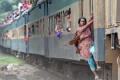 ট্রেনের ভেতরে জায়গা নেই, গেটও বন্ধ। জীবনের ঝুঁকি নিয়ে দরজার হাতল ধরে ঝুলে গন্তব্যে যাচ্ছেন এক নারী। শুক্রবার দুপুরে মহাখালীর চিত্র।